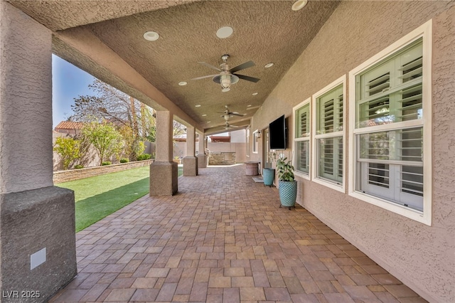 view of patio featuring a ceiling fan and fence