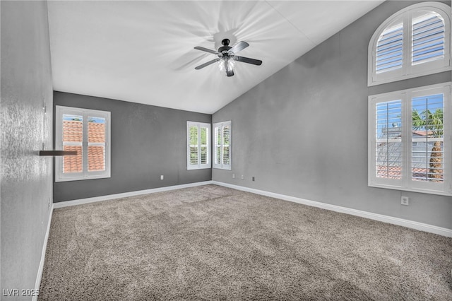 carpeted spare room featuring high vaulted ceiling, baseboards, and a ceiling fan