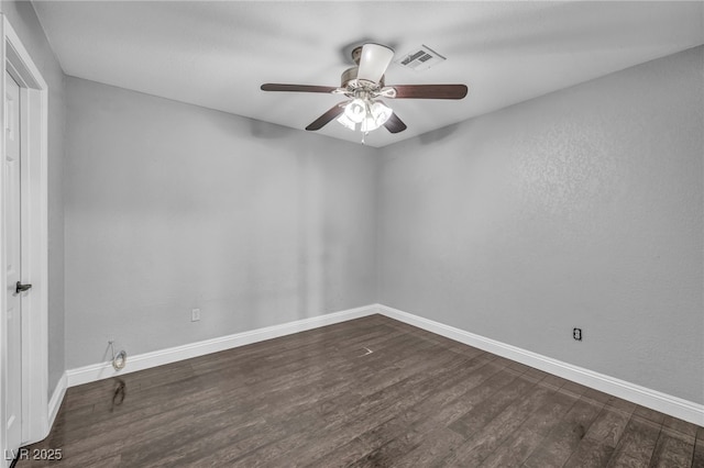 unfurnished room with a ceiling fan, dark wood-style flooring, visible vents, and baseboards