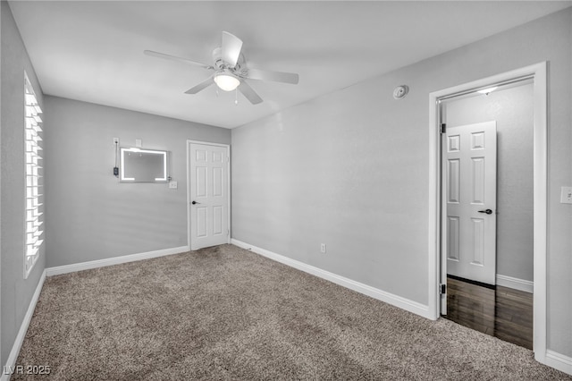 carpeted spare room featuring ceiling fan, a healthy amount of sunlight, and baseboards