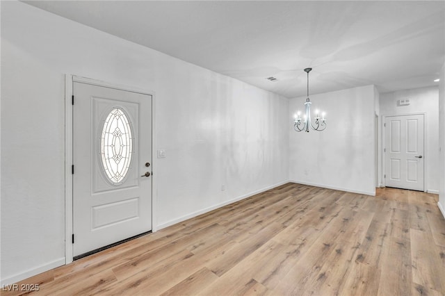 foyer entrance with light wood-style flooring, visible vents, baseboards, and a chandelier