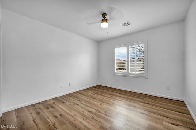 unfurnished room featuring visible vents, baseboards, ceiling fan, and wood finished floors