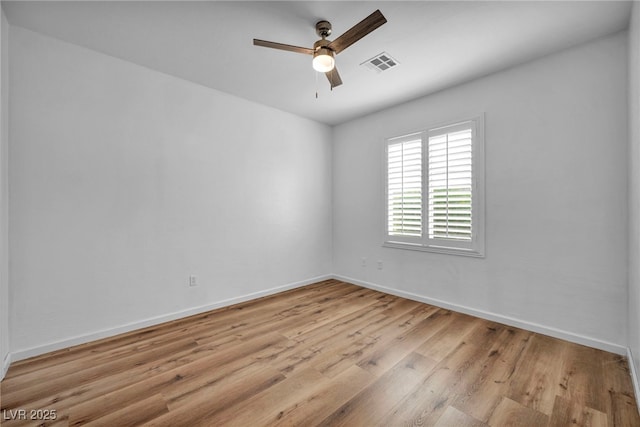 spare room featuring visible vents, light wood-style flooring, baseboards, and a ceiling fan