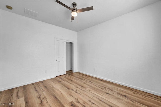 unfurnished bedroom with visible vents, a ceiling fan, wood finished floors, a closet, and baseboards