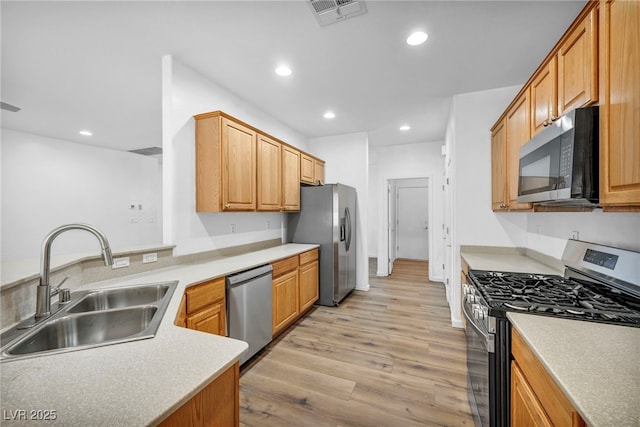 kitchen with visible vents, light wood finished floors, recessed lighting, a sink, and stainless steel appliances