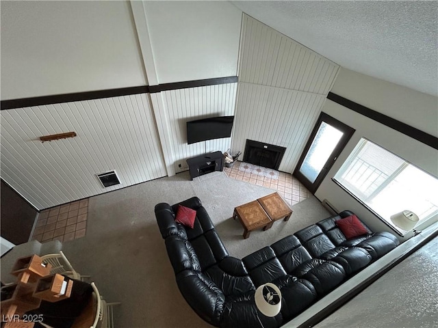 living area featuring a fireplace, visible vents, and a textured ceiling