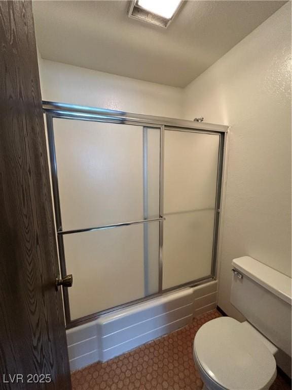 full bathroom featuring toilet, a shower with door, and visible vents