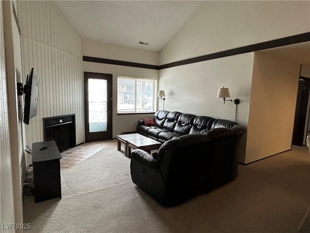 living area featuring vaulted ceiling, light tile patterned floors, light carpet, and visible vents