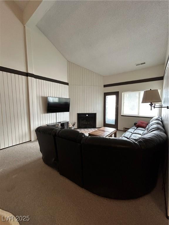 carpeted living area with a textured ceiling and visible vents