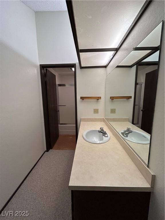 full bathroom featuring vanity, a textured ceiling, and an enclosed shower