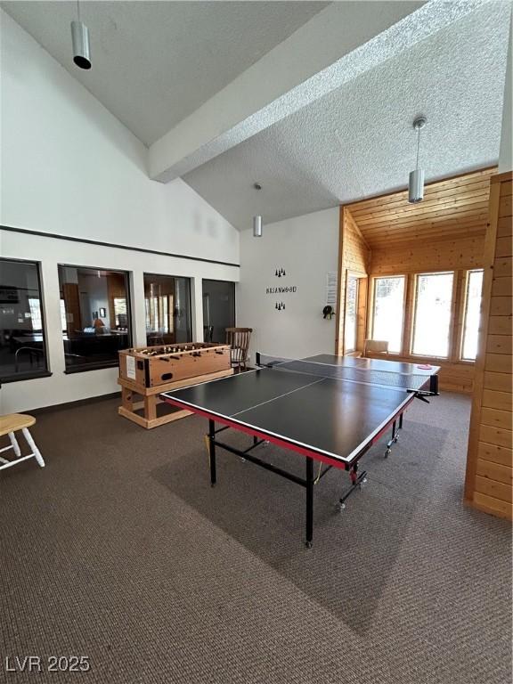 recreation room featuring a textured ceiling, high vaulted ceiling, carpet, and beam ceiling