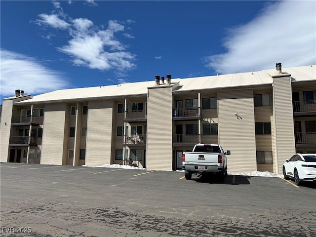 view of building exterior with uncovered parking