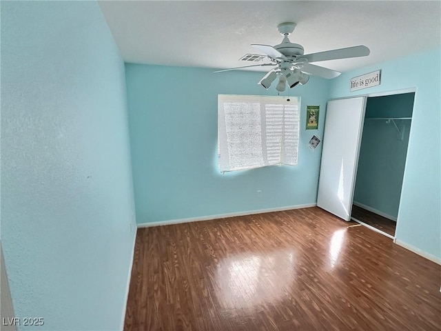 unfurnished bedroom with visible vents, baseboards, ceiling fan, wood finished floors, and a closet