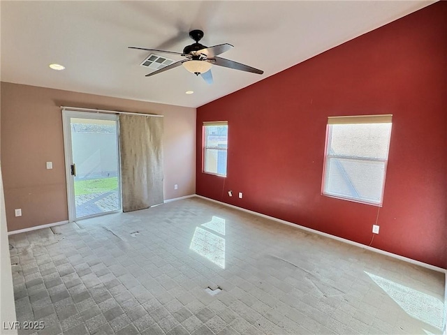 spare room with lofted ceiling, a healthy amount of sunlight, visible vents, and baseboards