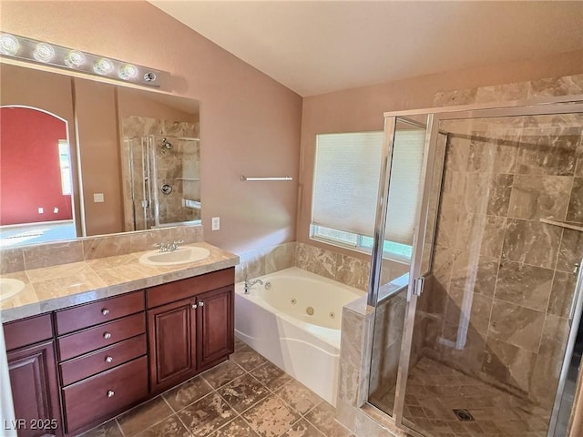 bathroom with a jetted tub, a shower stall, double vanity, and a sink