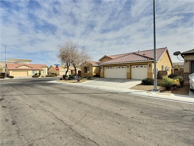 view of front of house with stucco siding, concrete driveway, an attached garage, a residential view, and a tiled roof