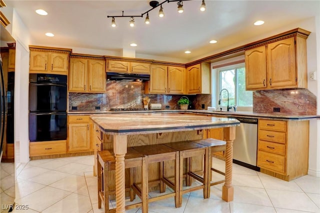 kitchen featuring light tile patterned floors, stainless steel appliances, a sink, and under cabinet range hood