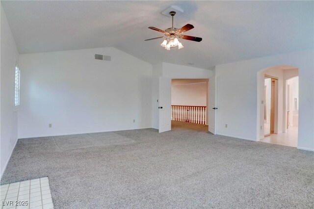 interior space with arched walkways, ceiling fan, lofted ceiling, light colored carpet, and visible vents