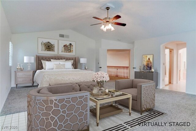 carpeted bedroom with arched walkways, visible vents, ceiling fan, and lofted ceiling