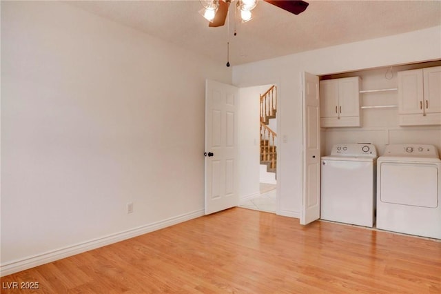 laundry area featuring cabinet space, light wood-style flooring, a ceiling fan, independent washer and dryer, and baseboards