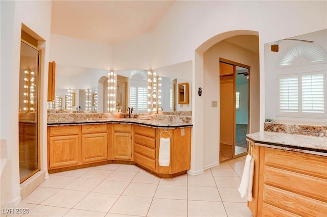 bathroom featuring a wealth of natural light, tile patterned flooring, a shower stall, and vanity