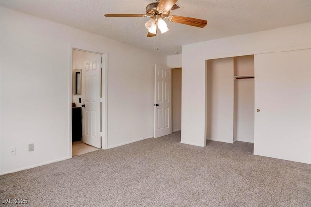 unfurnished bedroom with a textured ceiling, carpet floors, a closet, and ceiling fan