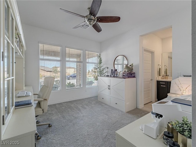 carpeted office with a ceiling fan