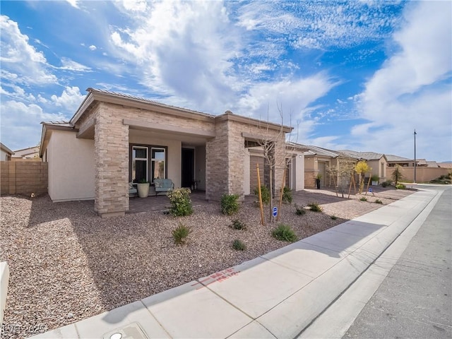 view of front of home with a porch, fence, and stucco siding