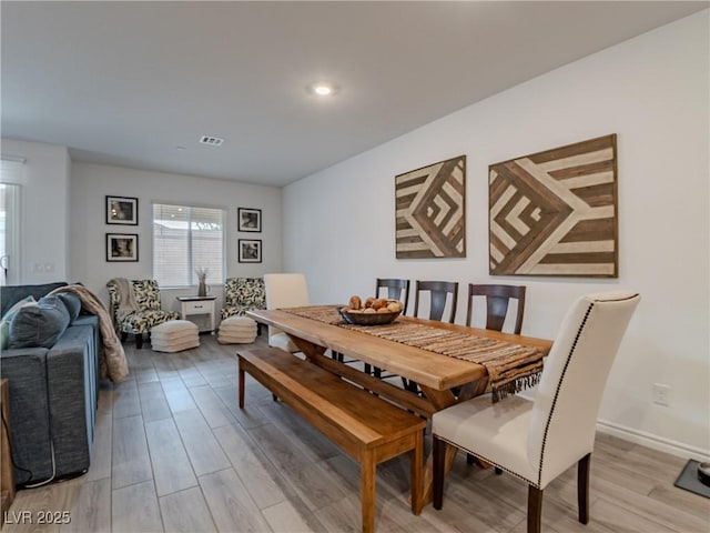 dining room featuring light wood-type flooring and baseboards