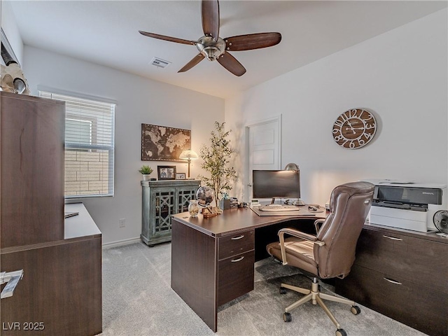 home office with a ceiling fan, light colored carpet, visible vents, and baseboards