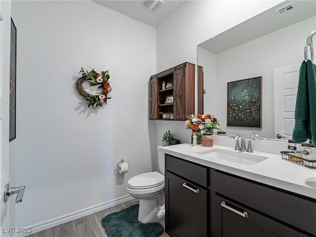 bathroom with toilet, baseboards, visible vents, and vanity