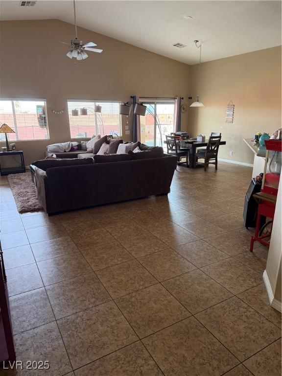 living room featuring visible vents, high vaulted ceiling, ceiling fan, and dark tile patterned flooring