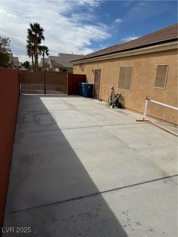 exterior space featuring a gate, fence, and stucco siding