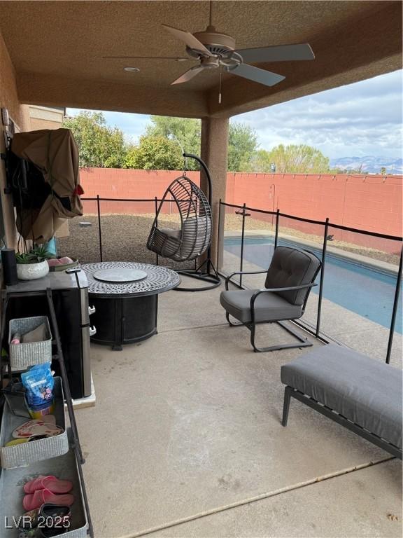 view of patio featuring an outdoor fire pit, a fenced backyard, and ceiling fan