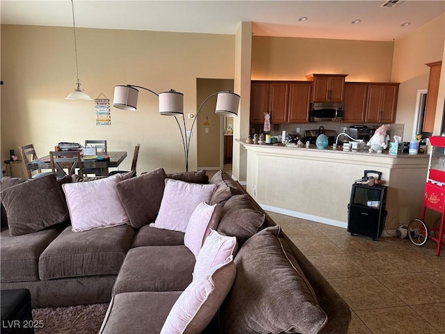 tiled living room with visible vents, recessed lighting, and a high ceiling