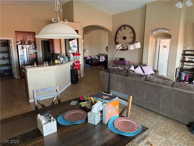 dining area featuring arched walkways, high vaulted ceiling, ceiling fan, and tile patterned flooring