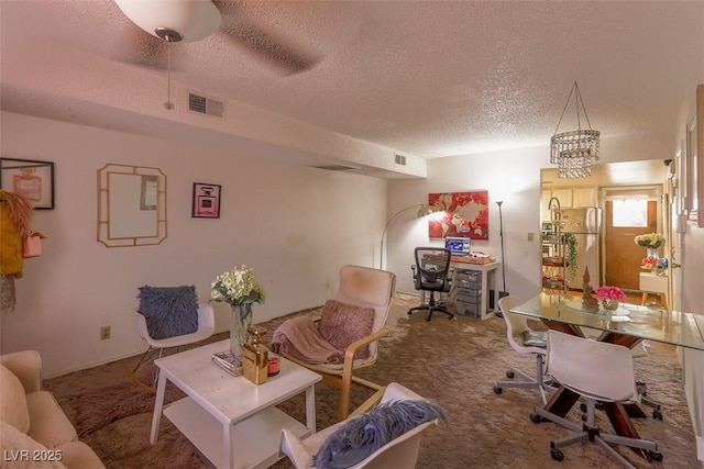 carpeted home office featuring visible vents and a textured ceiling