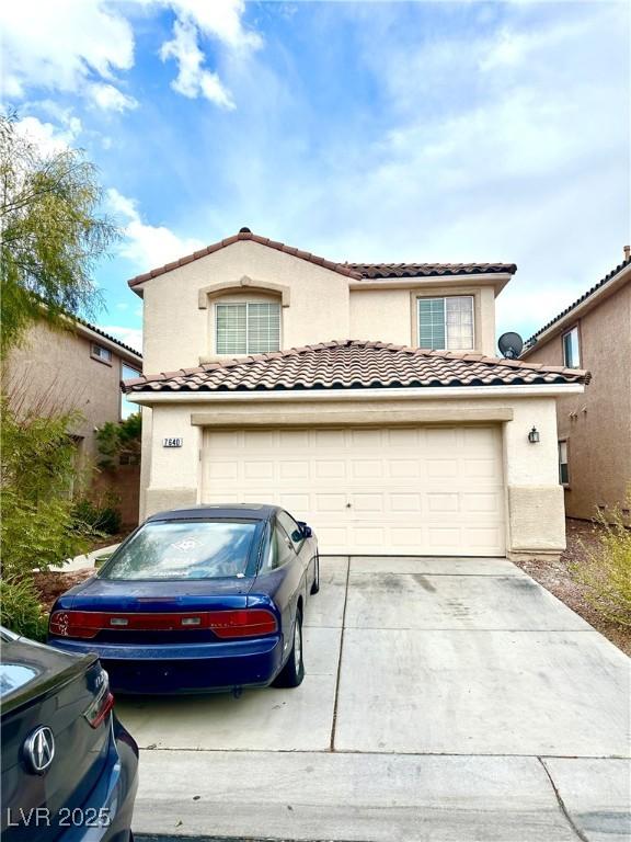 view of front of property featuring a garage, a tiled roof, concrete driveway, and stucco siding