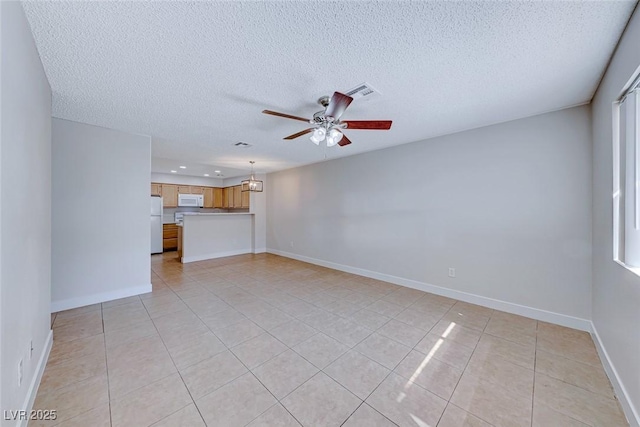 unfurnished living room featuring visible vents, a ceiling fan, light tile patterned flooring, a textured ceiling, and baseboards