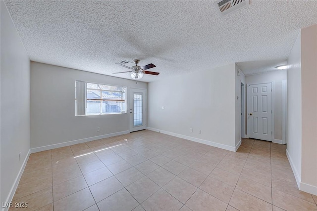 empty room with a ceiling fan, visible vents, baseboards, and light tile patterned flooring