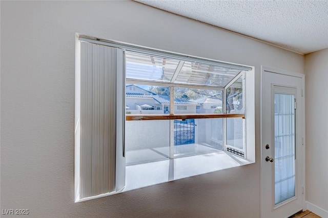 doorway to outside featuring a textured ceiling