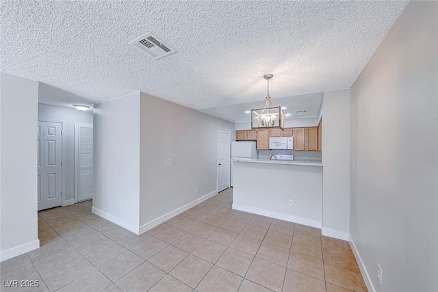 interior space featuring visible vents, an inviting chandelier, light tile patterned flooring, a textured ceiling, and baseboards