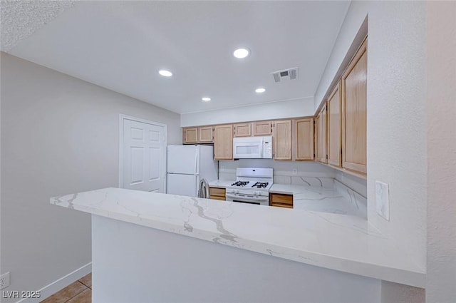 kitchen with light stone counters, recessed lighting, a peninsula, white appliances, and visible vents