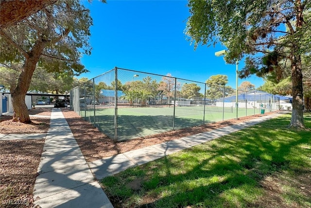 view of sport court with a lawn and fence