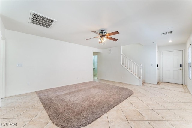 interior space featuring stairs, ceiling fan, light tile patterned floors, and visible vents