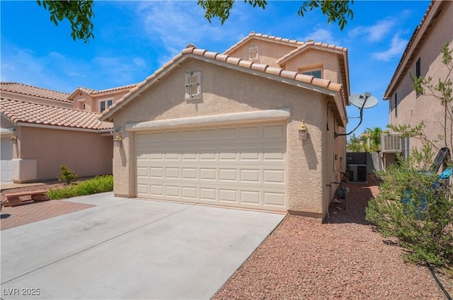 mediterranean / spanish house featuring a garage, concrete driveway, and stucco siding