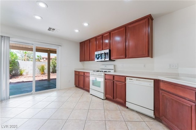 kitchen with white appliances, light tile patterned floors, visible vents, light countertops, and recessed lighting