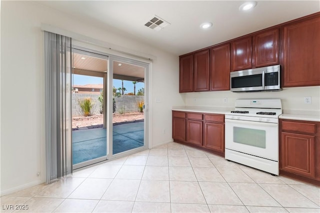 kitchen with recessed lighting, visible vents, light countertops, white gas range oven, and stainless steel microwave