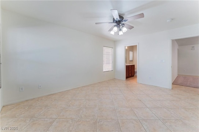 unfurnished bedroom featuring ceiling fan, light tile patterned flooring, and ensuite bath