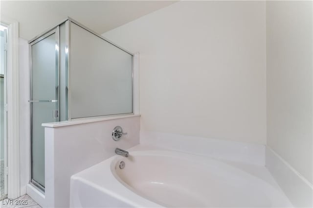 full bath featuring a stall shower and a garden tub